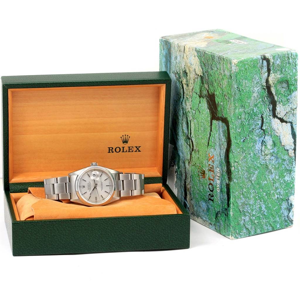 The Rolex Datejust 16200 Men's Stainless Steel Silver Dial 16200 Men's Stainless Steel Silver Dial watch is displayed in its green and wood box with an outer green-patterned box beside it.