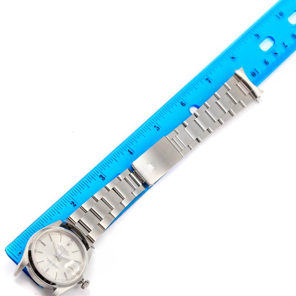 The image shows a Rolex Datejust 16200 Men's Stainless Steel Silver Dial 16200 Men's Stainless Steel Silver Dial watch with its face and full bracelet laid next to a blue ruler for measurement.