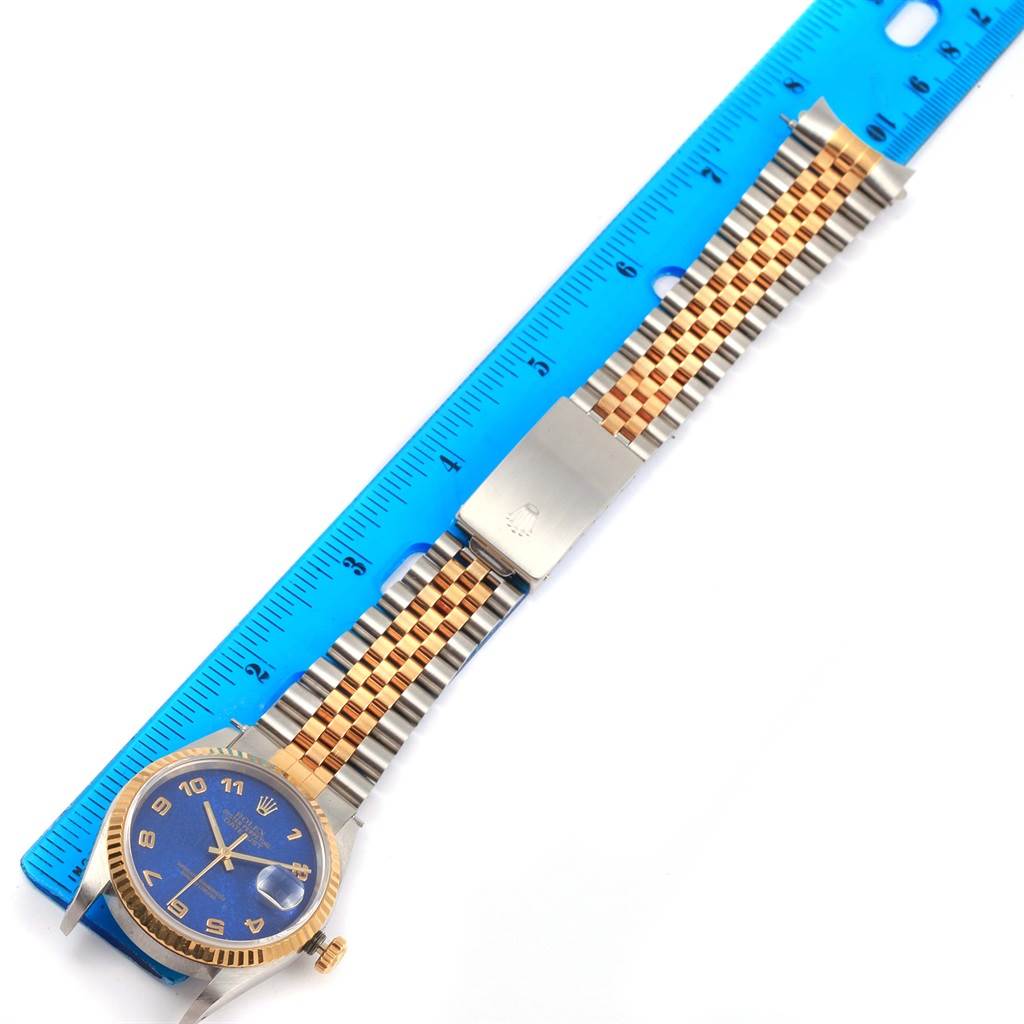 The Rolex Datejust 16233 Men's Steel and Gold (two tone) Blue Dial 16233 Men's Steel and Gold (two tone) Blue Dial watch is shown flat with a blue dial, two-tone Jubilee bracelet, and a caliper for measuring.