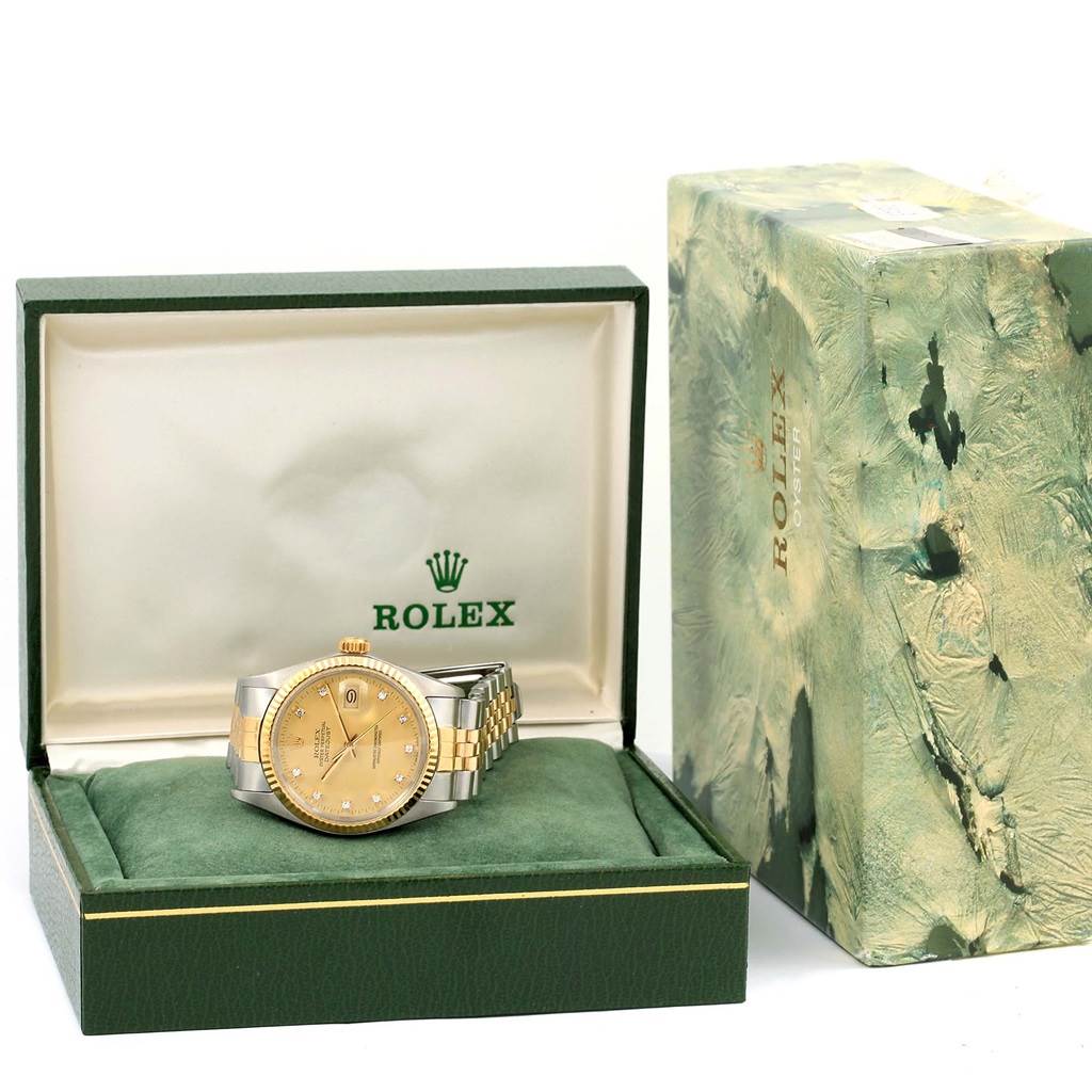 The Rolex Datejust 16013 Men's Stainless Steel Champagne Dial 16013 Men's Stainless Steel Champagne Dial watch is shown from a front angle inside its green and gold box with the outer packaging visible.