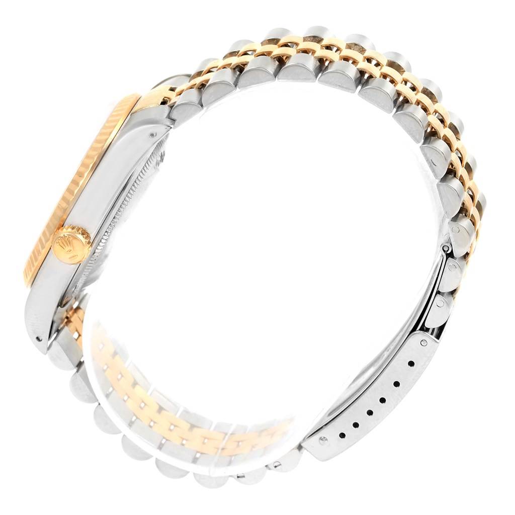 A side view of a Rolex Datejust 16233 Men's Steel and Gold (two tone) Champagne Dial 16233 Men's Steel and Gold (two tone) Champagne Dial watch, showing part of the case, crown, and a two-tone bracelet.