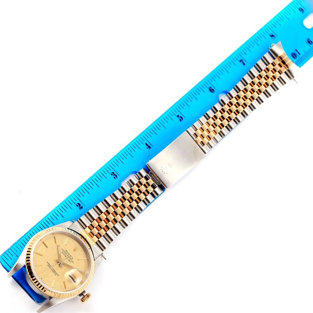 The image shows a Rolex Datejust 16233 Men's Steel and Gold (two tone) Champagne Dial 16233 Men's Steel and Gold (two tone) Champagne Dial watch from a top-down angle, displaying the face, bezel, and bracelet, measured against a ruler.