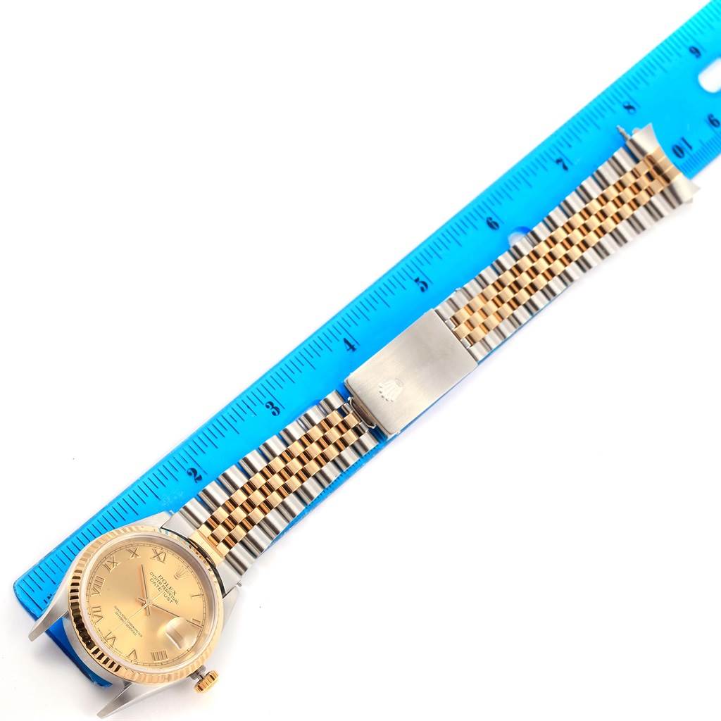 The image shows a Rolex Datejust 16233 Men's Steel and Gold (two tone) Champagne Dial 16233 Men's Steel and Gold (two tone) Champagne Dial watch laid flat against a blue ruler, displaying the dial and jubilee bracelet.