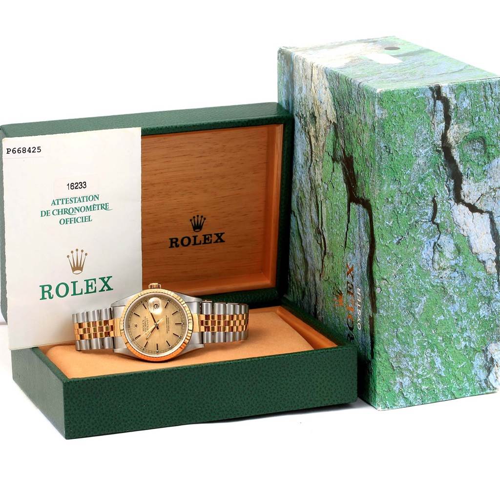 The Rolex Datejust 16233 Men's Steel and Gold (two tone) Champagne Dial 16233 Men's Steel and Gold (two tone) Champagne Dial watch is displayed inside its open box along with documentation, with the box lid slightly visible.