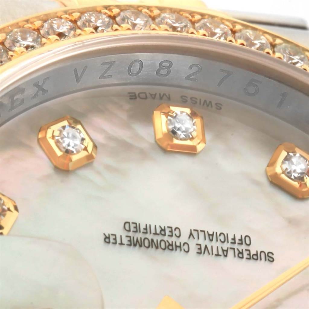 A close-up of the Rolex Datejust 116243 Women's Stainless Steel Mother of Pearl Dial 116243 Women's Stainless Steel Mother of Pearl Dial watch showing the serial number, diamonds, and part of the dial with branding text.