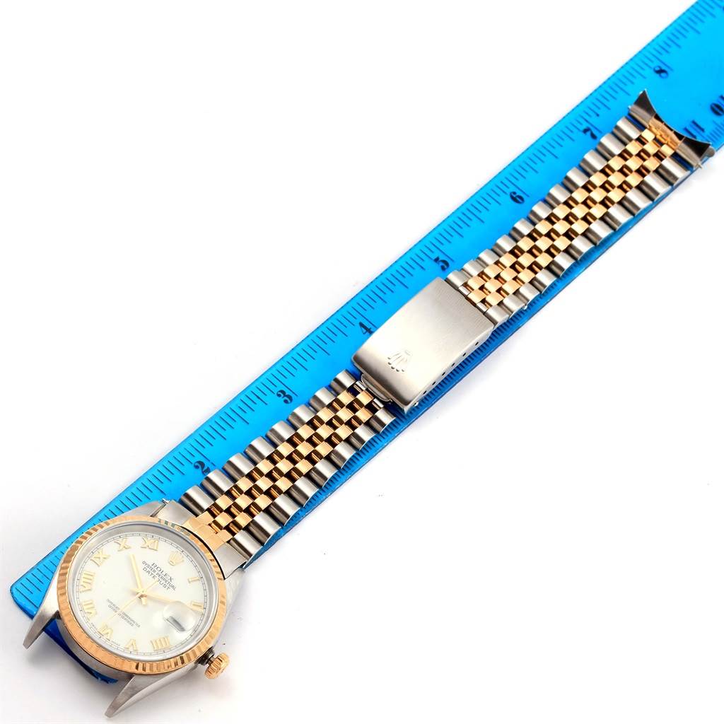 The Rolex Datejust 16233 Men's Steel and Gold (two tone) White Dial 16233 Men's Steel and Gold (two tone) White Dial watch is shown from a top-down angle, displaying the dial, bezel, crown, and bracelet with a measuring ruler beside it.