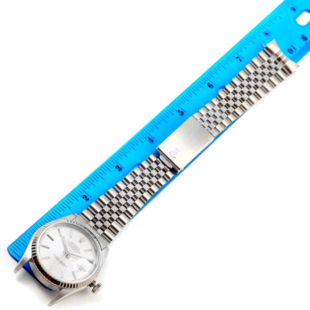 The image shows a Rolex Datejust 16234 Men's Stainless Steel Silver Dial 16234 Men's Stainless Steel Silver Dial watch laid flat with its bracelet alongside a blue ruler for measurement.