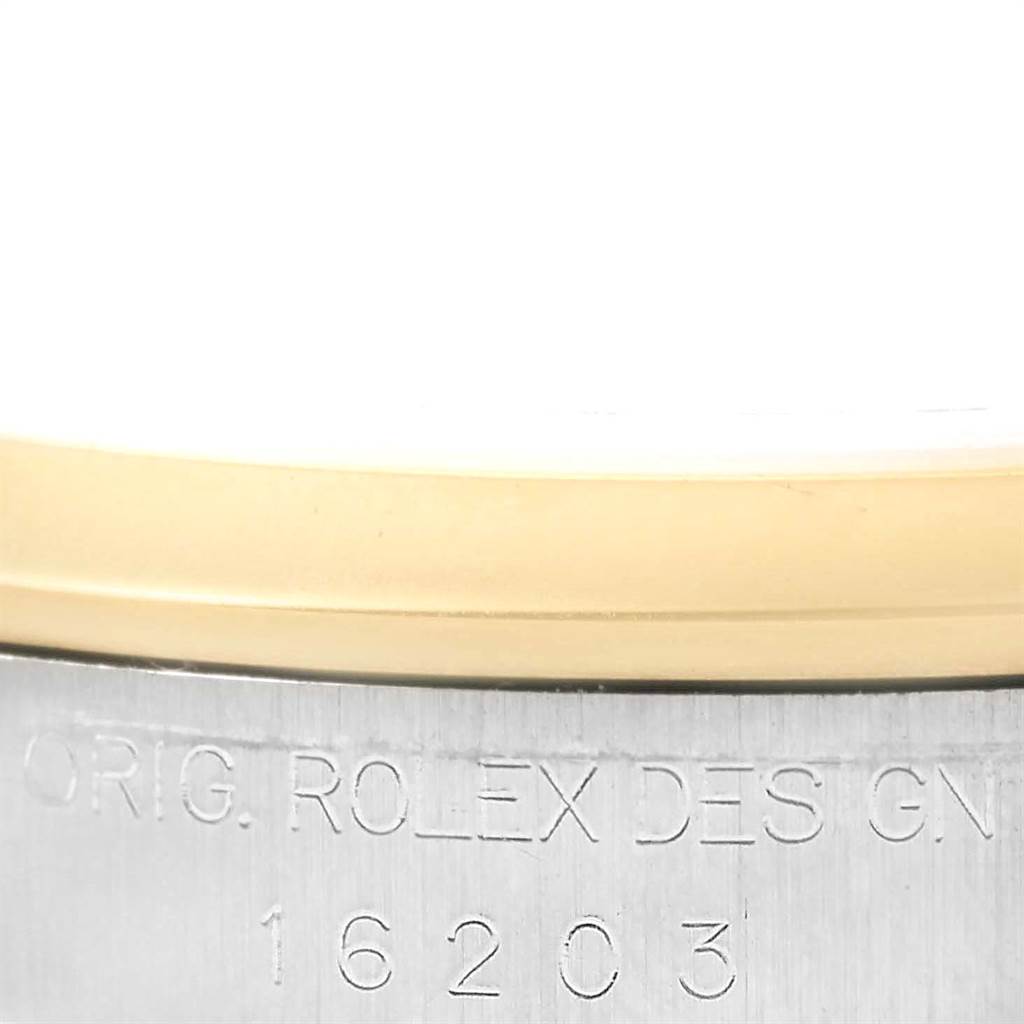 This image shows a close-up of the engraving on the case side of a Rolex Datejust 16203 Men's Steel and Gold (two tone) Beige Dial 16203 Men's Steel and Gold (two tone) Beige Dial 16203, revealing part of the model number and design signature.