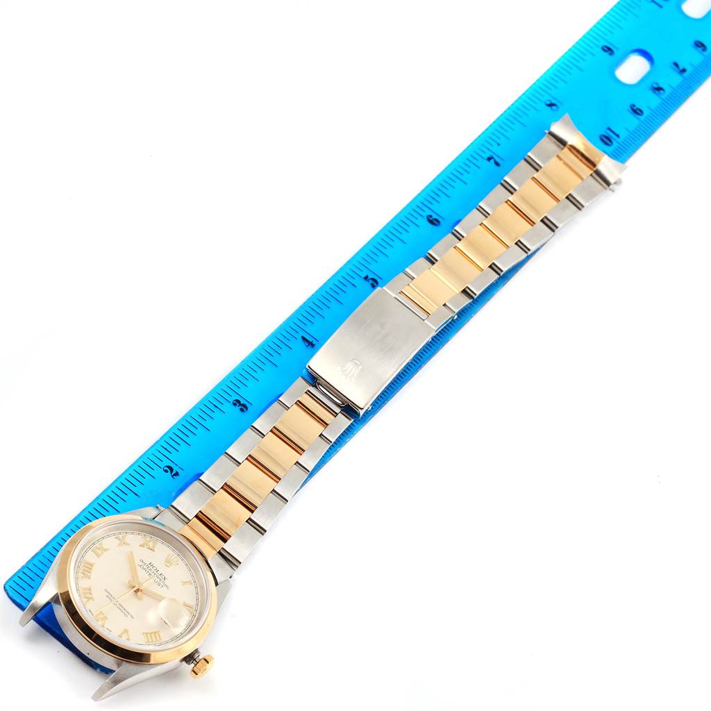 The Rolex Datejust 16203 Men's Steel and Gold (two tone) Beige Dial 16203 Men's Steel and Gold (two tone) Beige Dial watch is shown laying flat with its face, bracelet, and clasp visible next to a ruler.