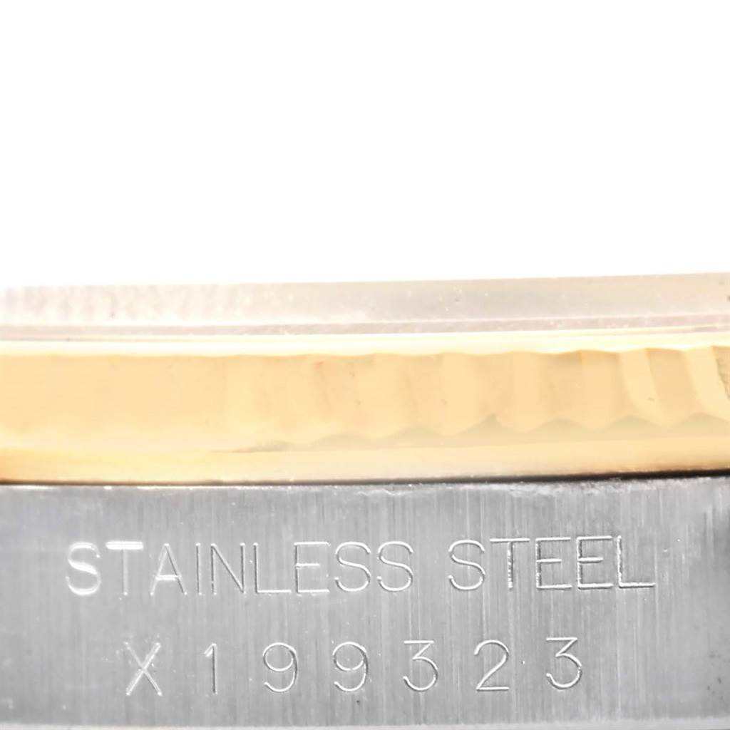 A close-up view of the Rolex Datejust 16233 Men's Steel and Gold (two tone) Blue Dial 16233 Men's Steel and Gold (two tone) Blue Dial watch, focusing on the stainless steel along with its serial number and part of the bezel.