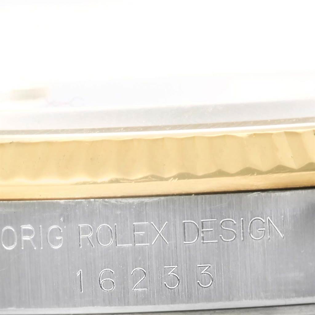 The image shows a close-up of the case side of a Rolex Datejust 16233 Men's Steel and Gold (two tone) Blue Dial 16233 Men's Steel and Gold (two tone) Blue Dial watch, highlighting its engraving and bezel details.