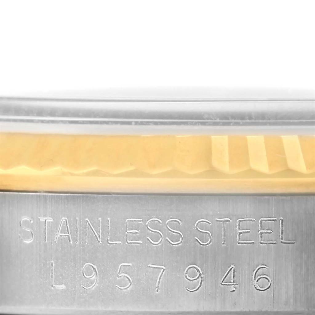 This close-up image shows the side of the Rolex Datejust 16233 Steel and Gold (two tone) Champagne Dial 16233 Steel and Gold (two tone) Champagne Dial, focusing on the stainless steel part with engraved serial numbers and part of the bezel.