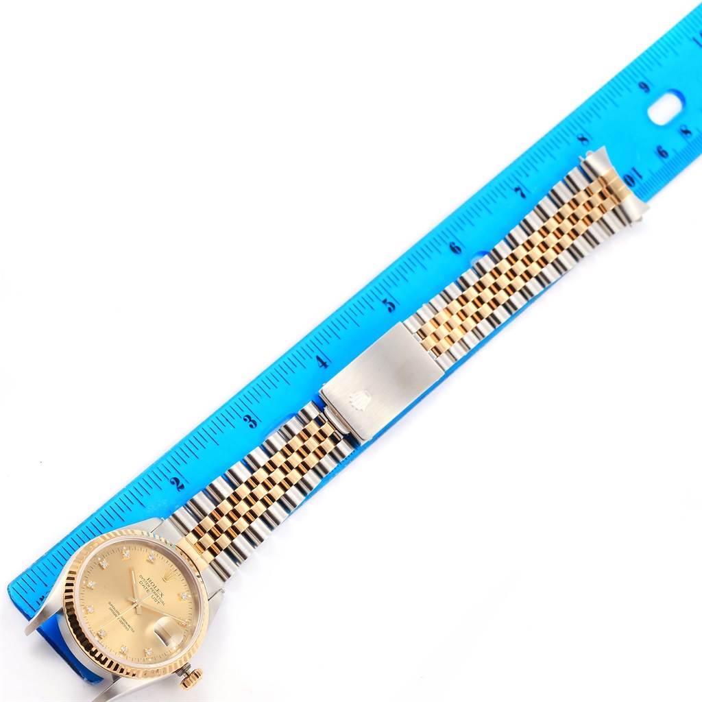 The image shows a Rolex Datejust 16233 Steel and Gold (two tone) Champagne Dial 16233 Steel and Gold (two tone) Champagne Dial watch laid flat alongside a blue ruler, displaying the face and bracelet.