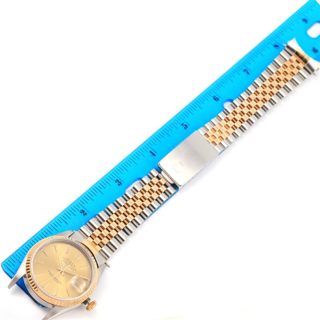 The image shows a Rolex Datejust 16233 Men's Steel and Gold (two tone) Champagne Dial 16233 Men's Steel and Gold (two tone) Champagne Dial watch laid flat next to a ruler, displaying its full band and face.