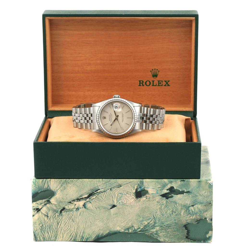 The Rolex Datejust 16220 Men's Stainless Steel Silver Dial 16220 Men's Stainless Steel Silver Dial watch is shown from the front, resting in an open green and wooden Rolex box.