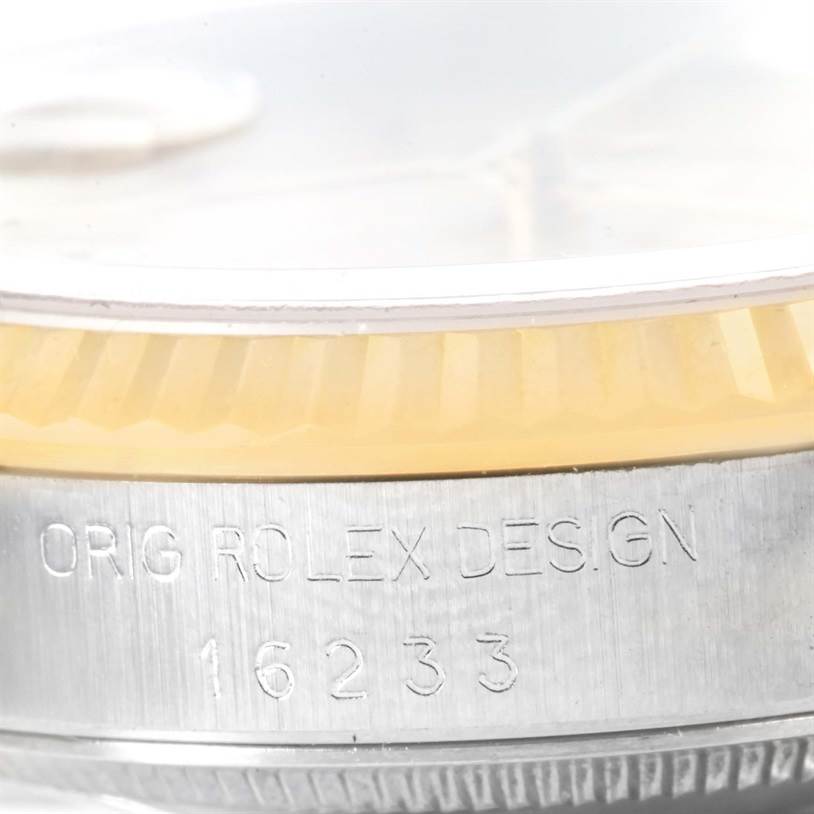 The image shows the side of a Rolex Datejust 16233 Men's Steel and Gold (two tone) Champagne Dial 16233 Men's Steel and Gold (two tone) Champagne Dial watch, focusing on the engraved reference number "16233" and "ORIG ROLEX DESIGN."