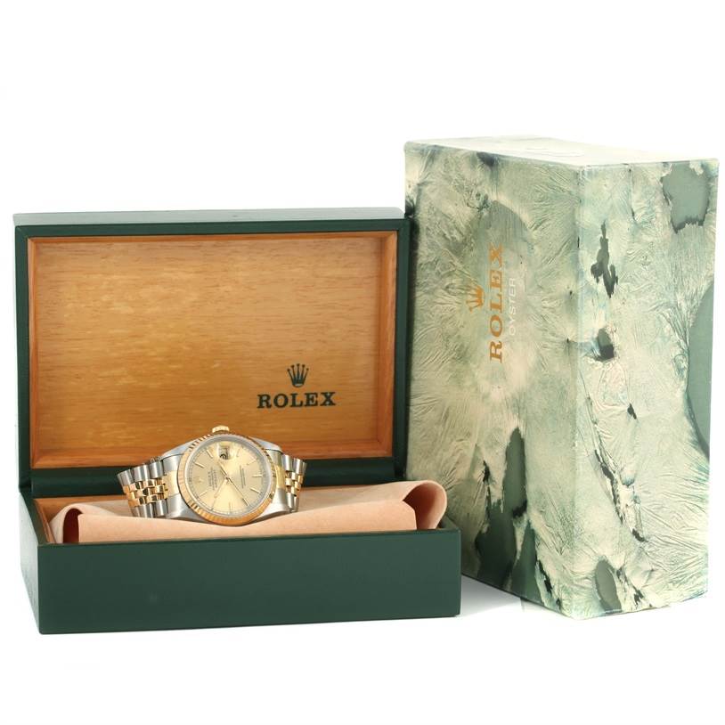 The image shows a Rolex Datejust 16233 Men's Steel and Gold (two tone) Champagne Dial 16233 Men's Steel and Gold (two tone) Champagne Dial watch in a green and wooden box with the outer packaging beside it.