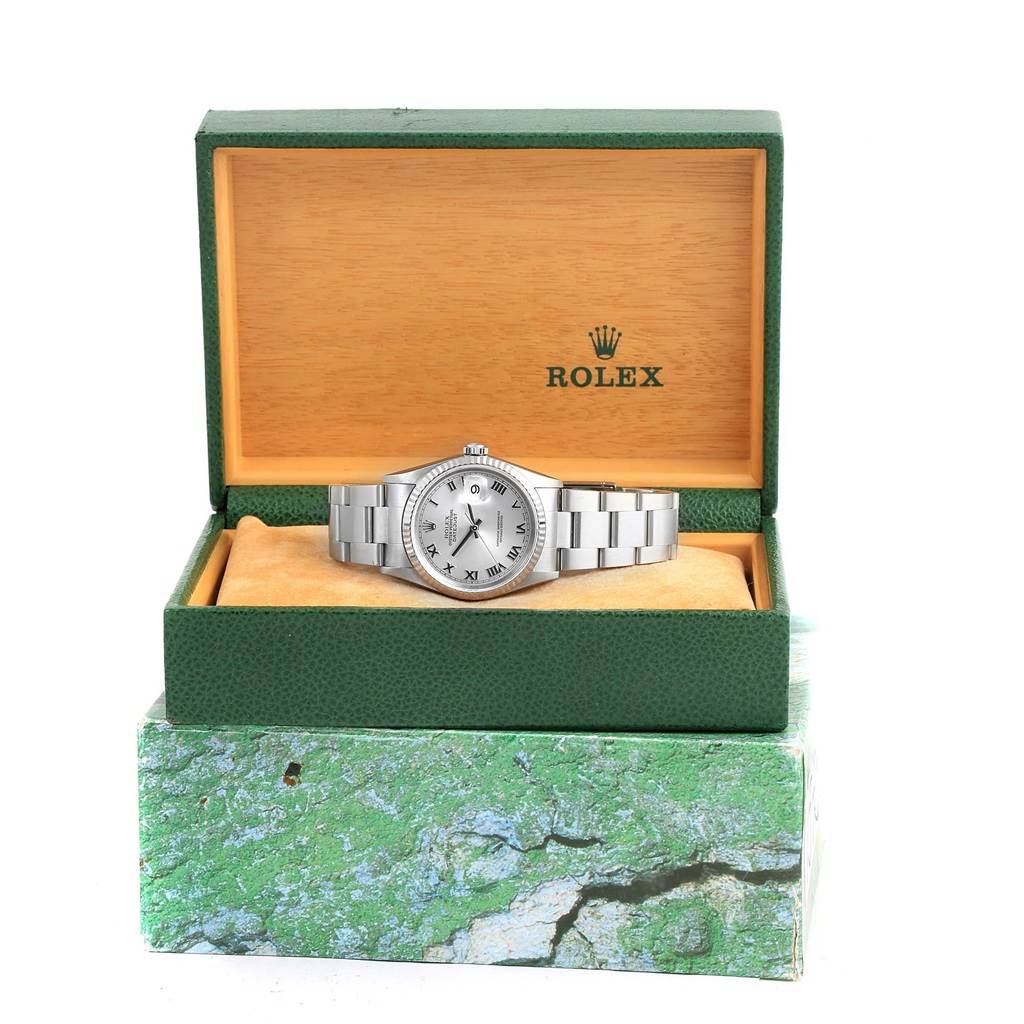 The Rolex Datejust 16234 Men's Stainless Steel Silver Dial 16234 Men's Stainless Steel Silver Dial watch is shown from the front inside its green and beige branded box.
