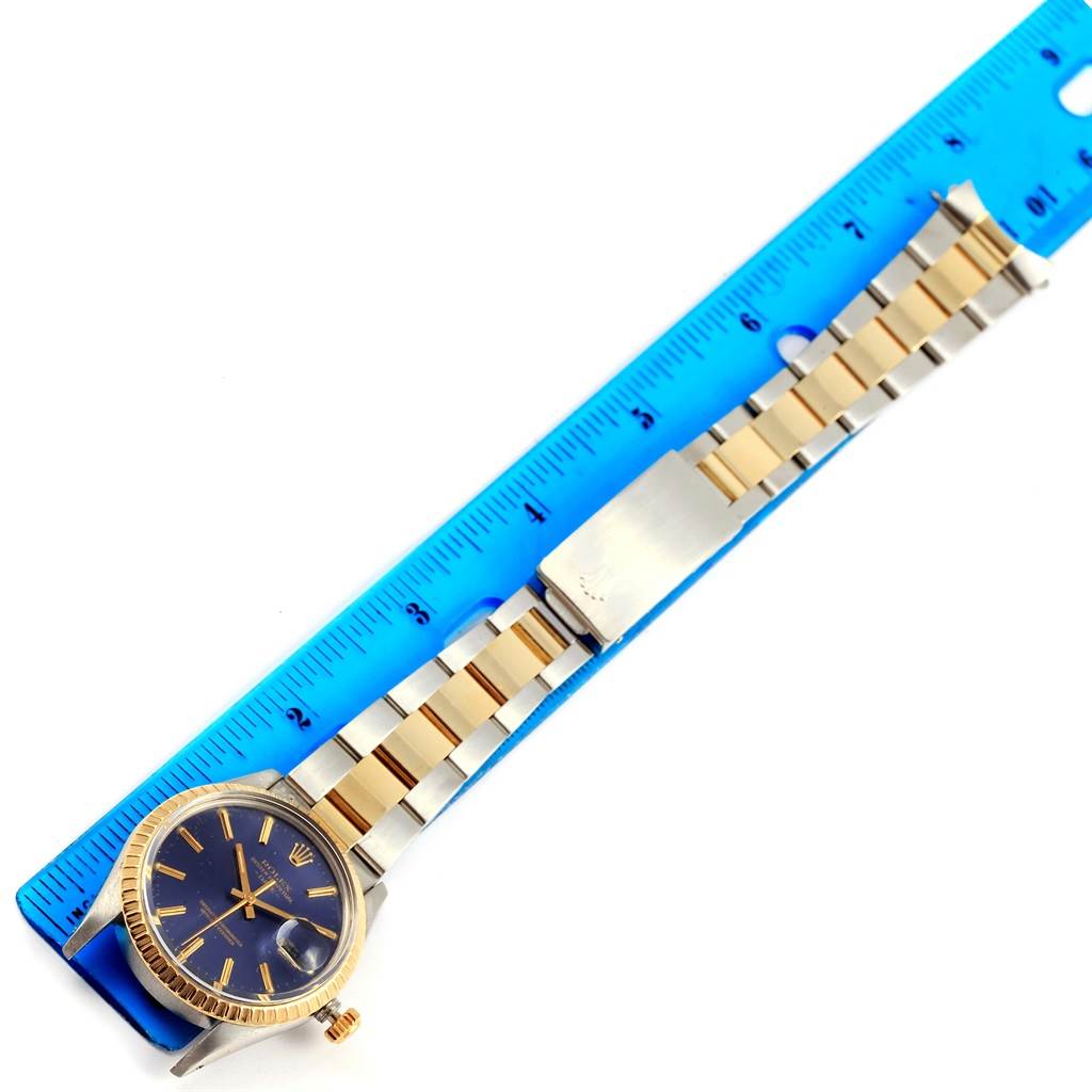 The image shows a top-down view of a Rolex Datejust 15053 Men's Steel and Gold (two tone) Blue Dial 15053 Men's Steel and Gold (two tone) Blue Dial watch, including the dial, bracelet, and clasp alongside a blue ruler.