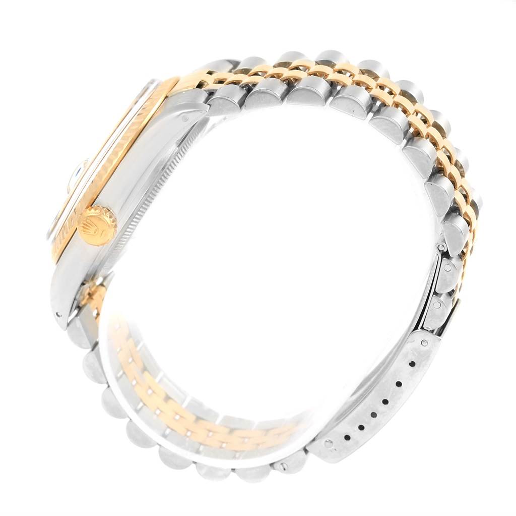 This side-angle view of the Rolex Datejust 16013 Men's Stainless Steel Champagne Dial 16013 Men's Stainless Steel Champagne Dial shows the case, crown, and two-tone bracelet.