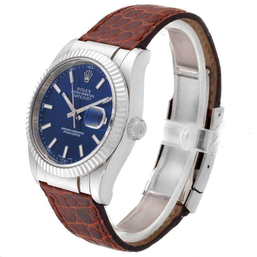 This Rolex Datejust 116139 Men's White Gold Blue Dial 116139 Men's White Gold Blue Dial watch is shown from an angled side view, displaying the blue dial, fluted bezel, crown, and brown leather strap.