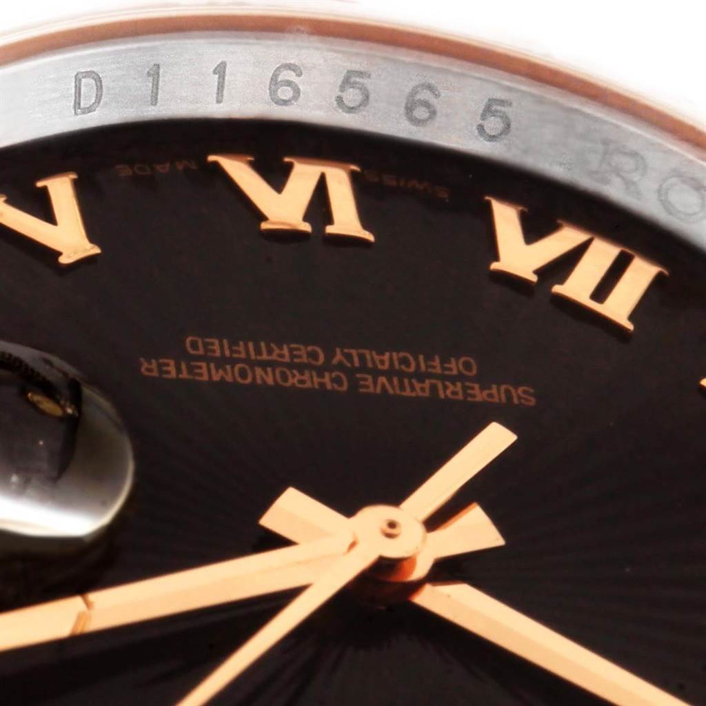 The image shows a close-up angled view of a Rolex Datejust 116231 Men's Steel and Gold (two tone) Black Dial 116231 Men's Steel and Gold (two tone) Black Dial watch, highlighting the hands, Roman numerals, part of the dial, and serial number.
