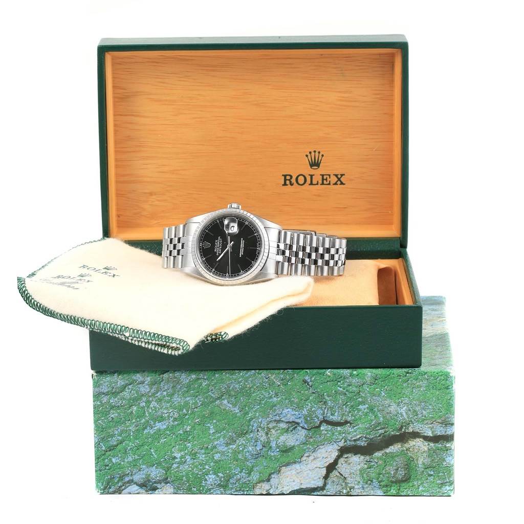 The Rolex Datejust 16220 Men's Stainless Steel Black Dial 16220 Men's Stainless Steel Black Dial watch is shown front-facing inside its branded box atop a green textured outer box.