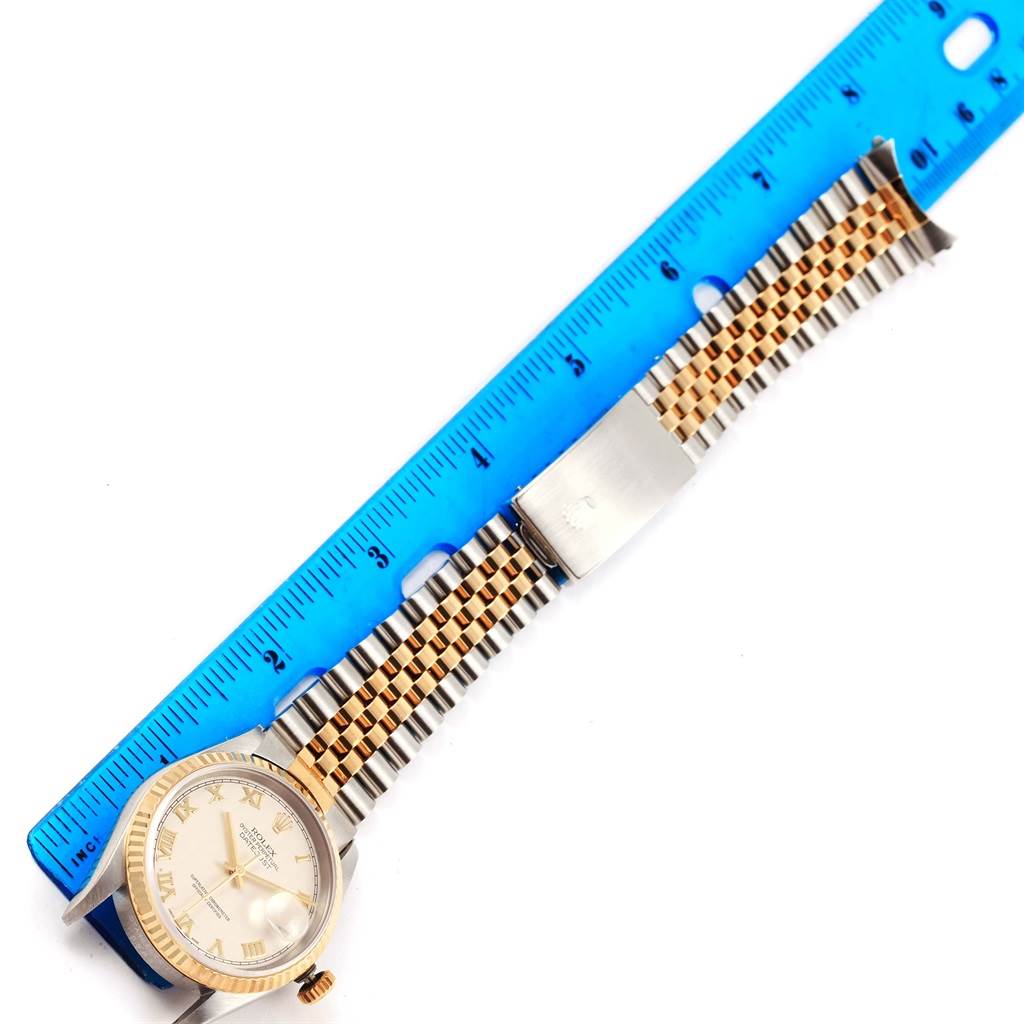 The image shows a Rolex Datejust 16233 Men's Steel and Gold (two tone) Beige Dial 16233 Men's Steel and Gold (two tone) Beige Dial watch with a two-tone metal bracelet next to a blue ruler measuring its length.