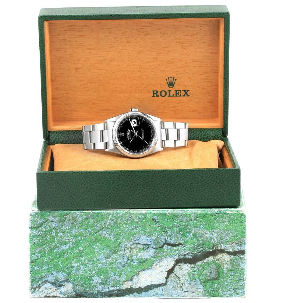 The Rolex Datejust 16200 Men's Stainless Steel Black Dial 16200 Men's Stainless Steel Black Dial watch is shown from the front, inside an open green and wood box, highlighting the face and bracelet.