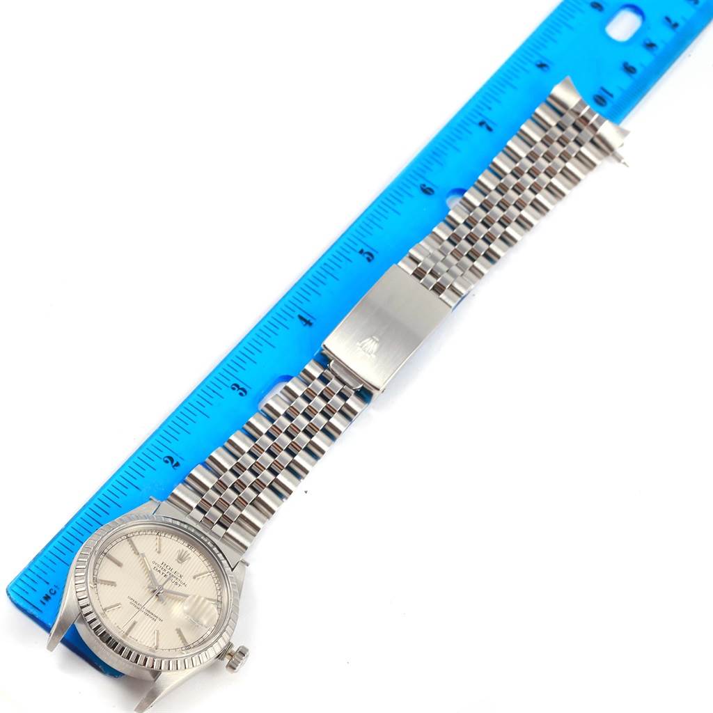 The image shows a top view of a Rolex Datejust 16030 Men's Stainless Steel Silver Dial 16030 Men's Stainless Steel Silver Dial watch with its bracelet, placed beside a blue measuring ruler.