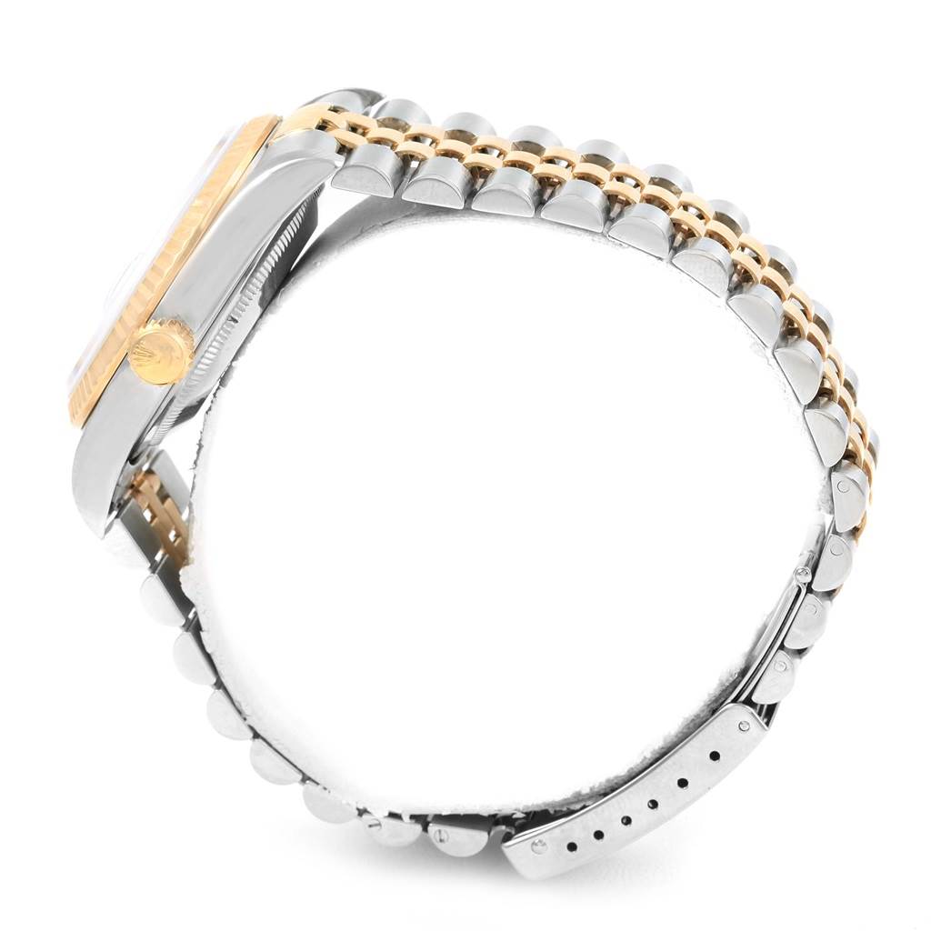 The side view of the Rolex Datejust 16233 Men's Steel and Gold (two tone) Champagne Dial 16233 Men's Steel and Gold (two tone) Champagne Dial watch shows the crown, bezel, and two-tone bracelet with clasp.