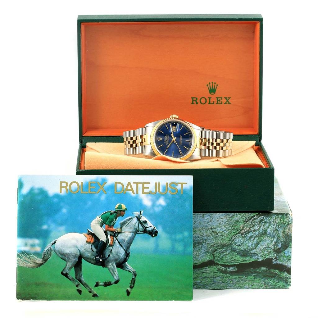 The Rolex Datejust 16233 Men's Steel and Gold (two tone) Blue Dial 16233 Men's Steel and Gold (two tone) Blue Dial watch is shown front-facing in a green box with a booklet in front.