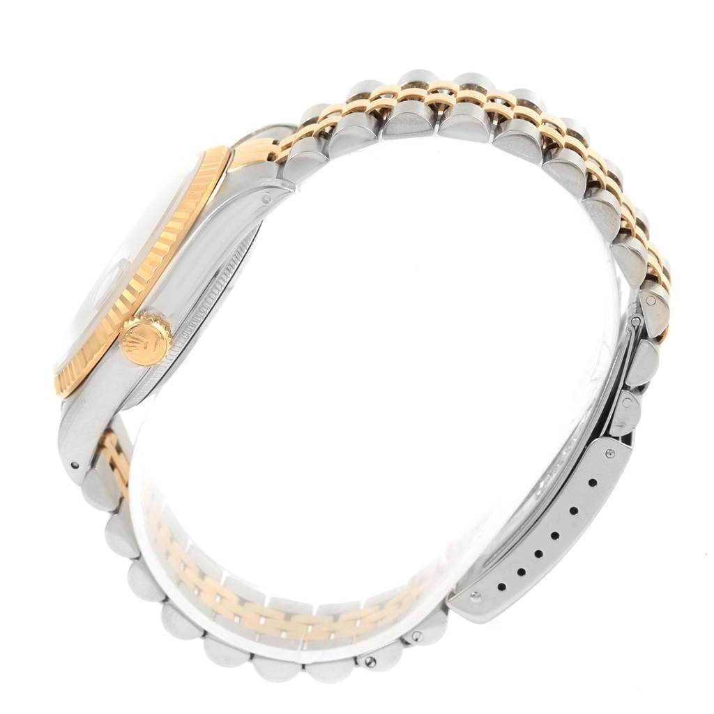 The image shows a side view of a Rolex Datejust 16233 Men's Steel and Gold (two tone) Blue Dial 16233 Men's Steel and Gold (two tone) Blue Dial watch emphasizing its crown, bezel, and bracelet.