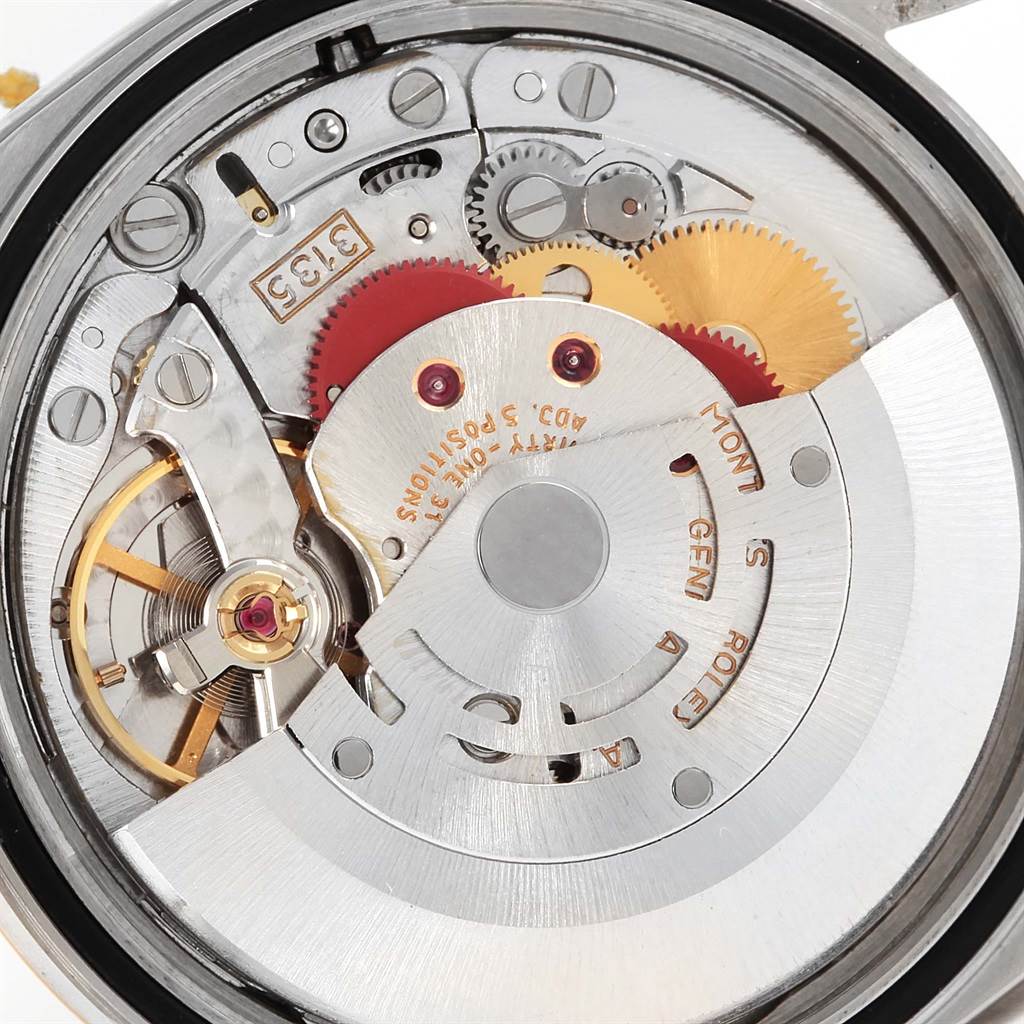 This image shows a close-up view of the movement mechanism of a Rolex Datejust 16233 Men's Steel and Gold (two tone) Blue Dial 16233 Men's Steel and Gold (two tone) Blue Dial watch, revealing gears and the rotor.