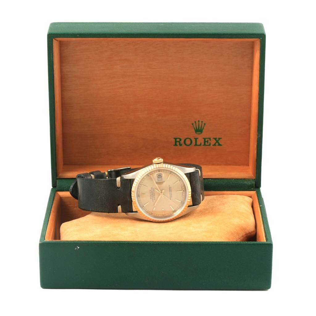 The Rolex Datejust 16233 Men's Steel and Gold (two tone) Champagne Dial 16233 Men's Steel and Gold (two tone) Champagne Dial watch is shown from the front, displayed in an open green and wooden box with the brand logo inside.