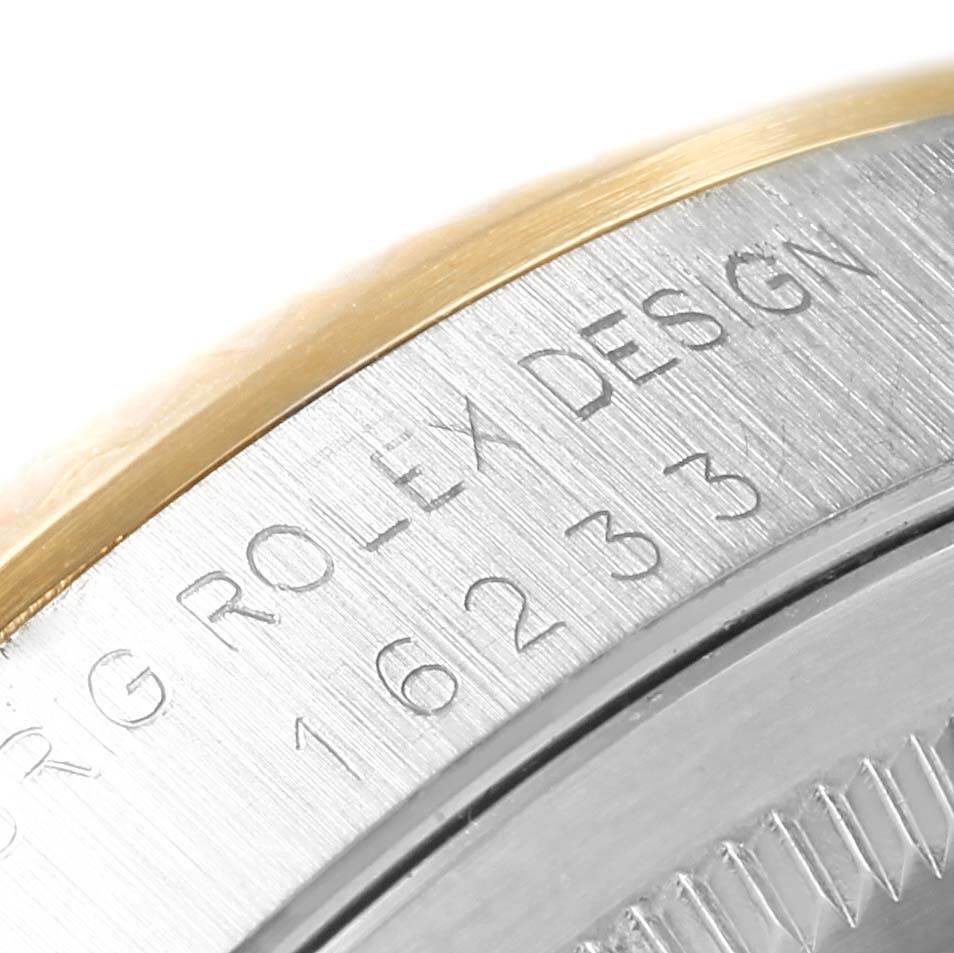 The image shows a close-up of the Rolex Datejust 16233 Men's Steel and Gold (two tone) Champagne Dial 16233 Men's Steel and Gold (two tone) Champagne Dial model's case with engraved text and part of the bezel.