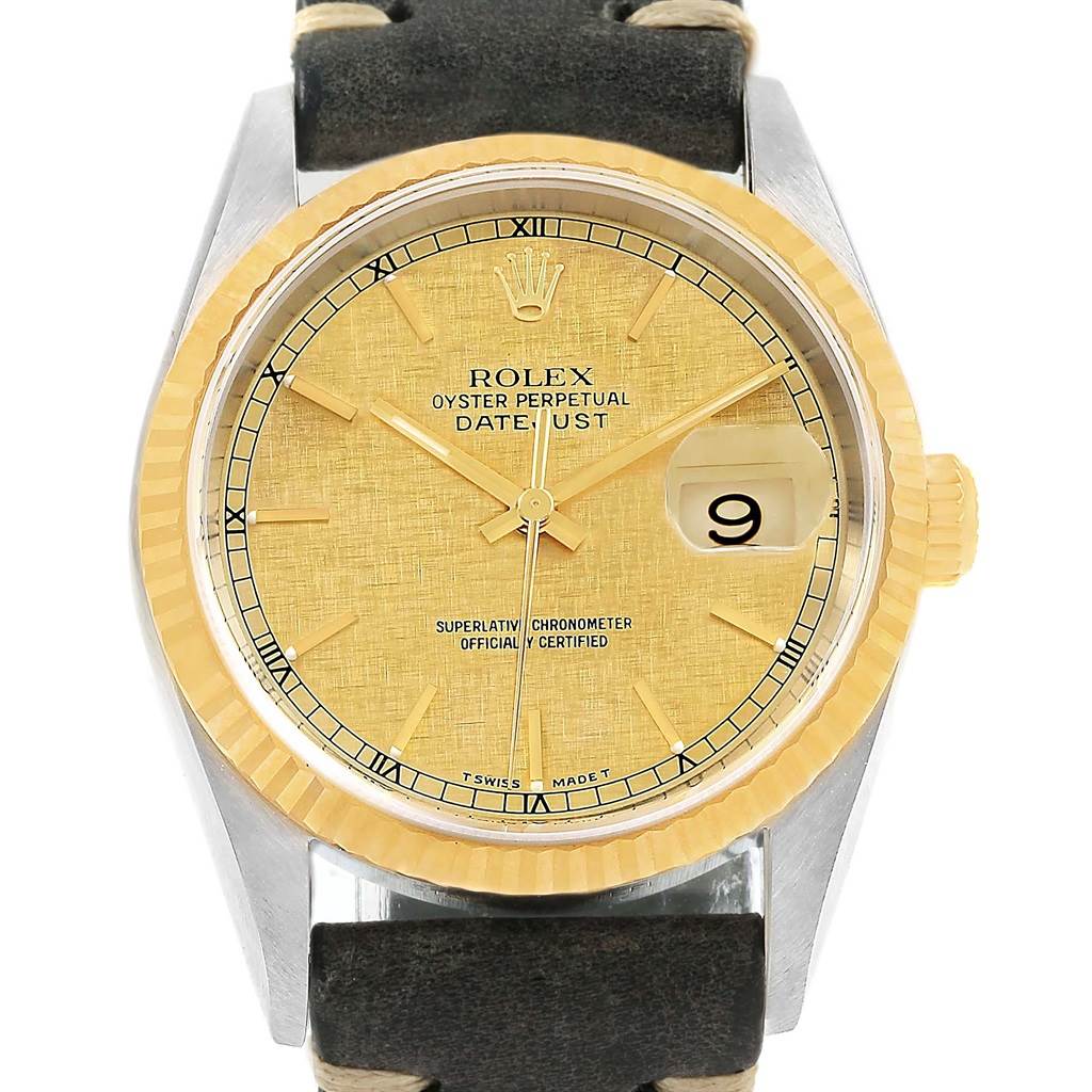 This image shows the face of a Rolex Datejust 16233 Men's Steel and Gold (two tone) Champagne Dial 16233 Men's Steel and Gold (two tone) Champagne Dial watch, featuring a yellow-gold dial, fluted bezel, and black leather strap.