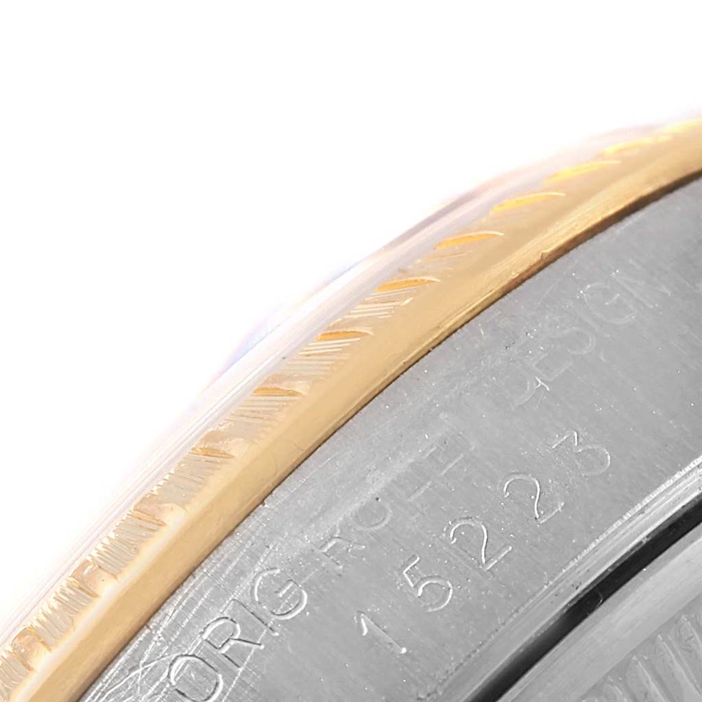 The image shows a close-up of the bezel and the engraved case side of the Rolex Datejust 15223 Men's Steel and Gold (two tone) Blue Dial 15223 Men's Steel and Gold (two tone) Blue Dial watch.