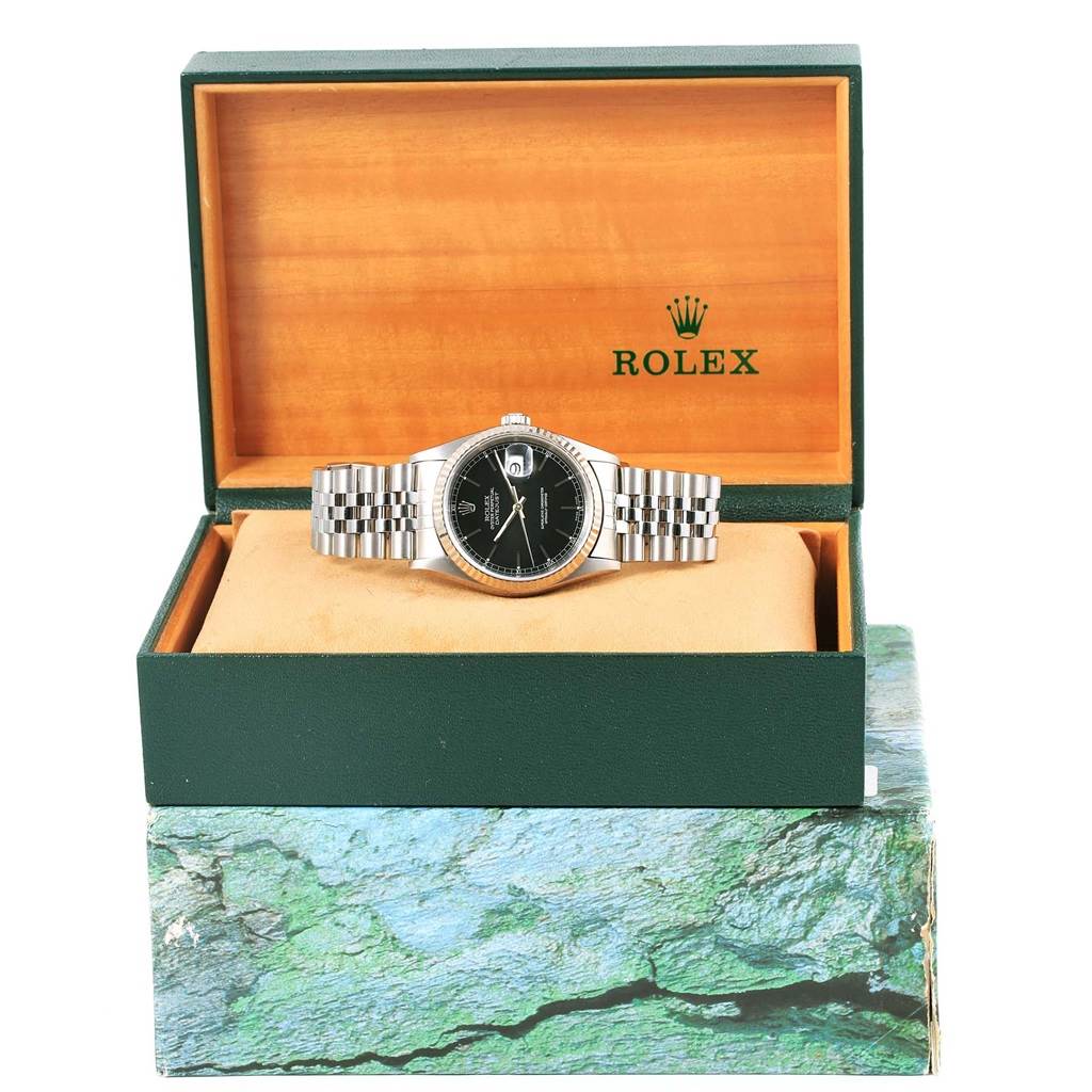 The Rolex Datejust 16234 Men's Stainless Steel Black Dial 16234 Men's Stainless Steel Black Dial watch is displayed frontally in an open box, showcasing its face and bracelet.