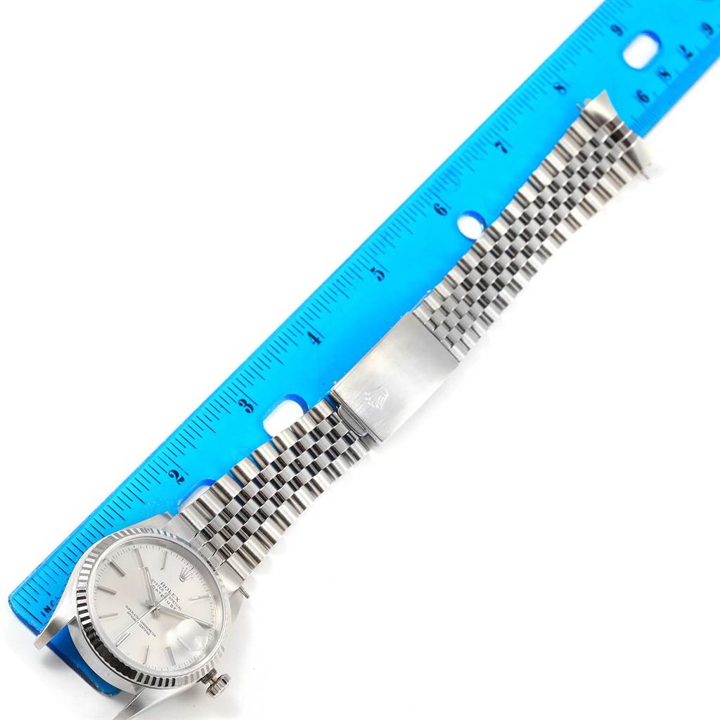 The image shows a Rolex Datejust 16234 Men's Stainless Steel Silver Dial 16234 Men's Stainless Steel Silver Dial watch lying flat with its bracelet extended next to a blue ruler.