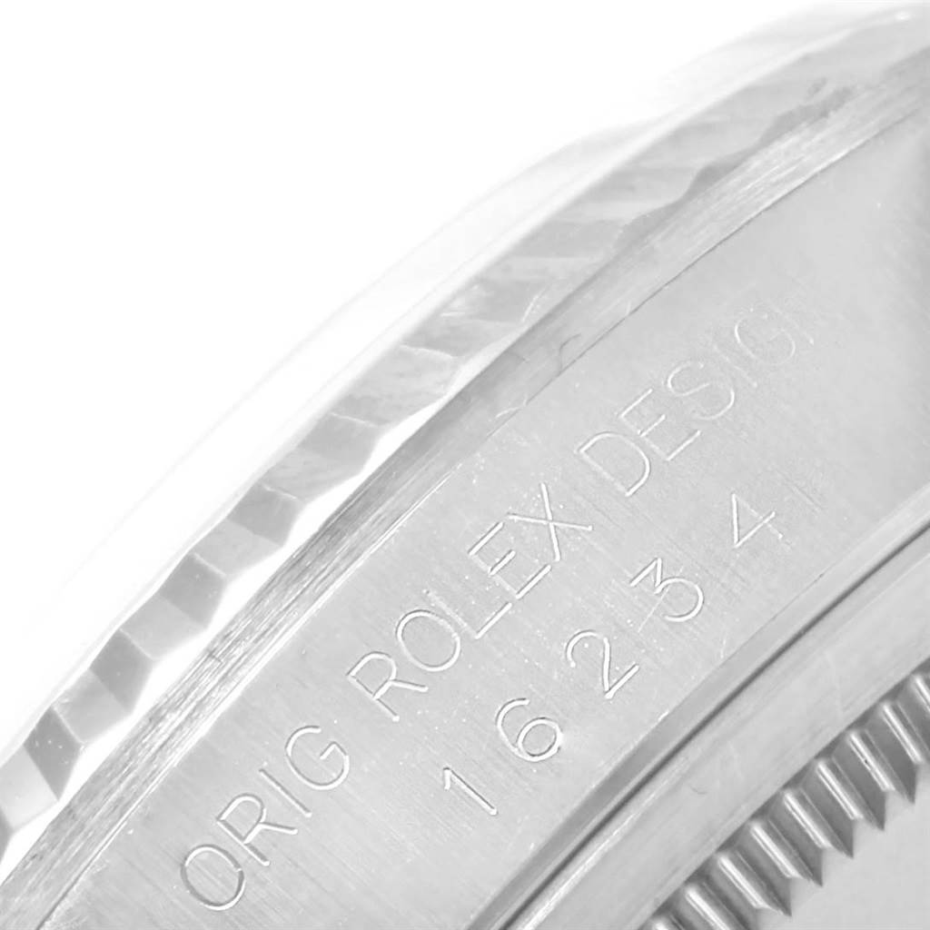 The image shows a close-up of the engraved side of a Rolex Datejust 16234 Men's Stainless Steel Beige Dial 16234 Men's Stainless Steel Beige Dial watch, displaying "ORIG ROLEX DESIGN 16234."