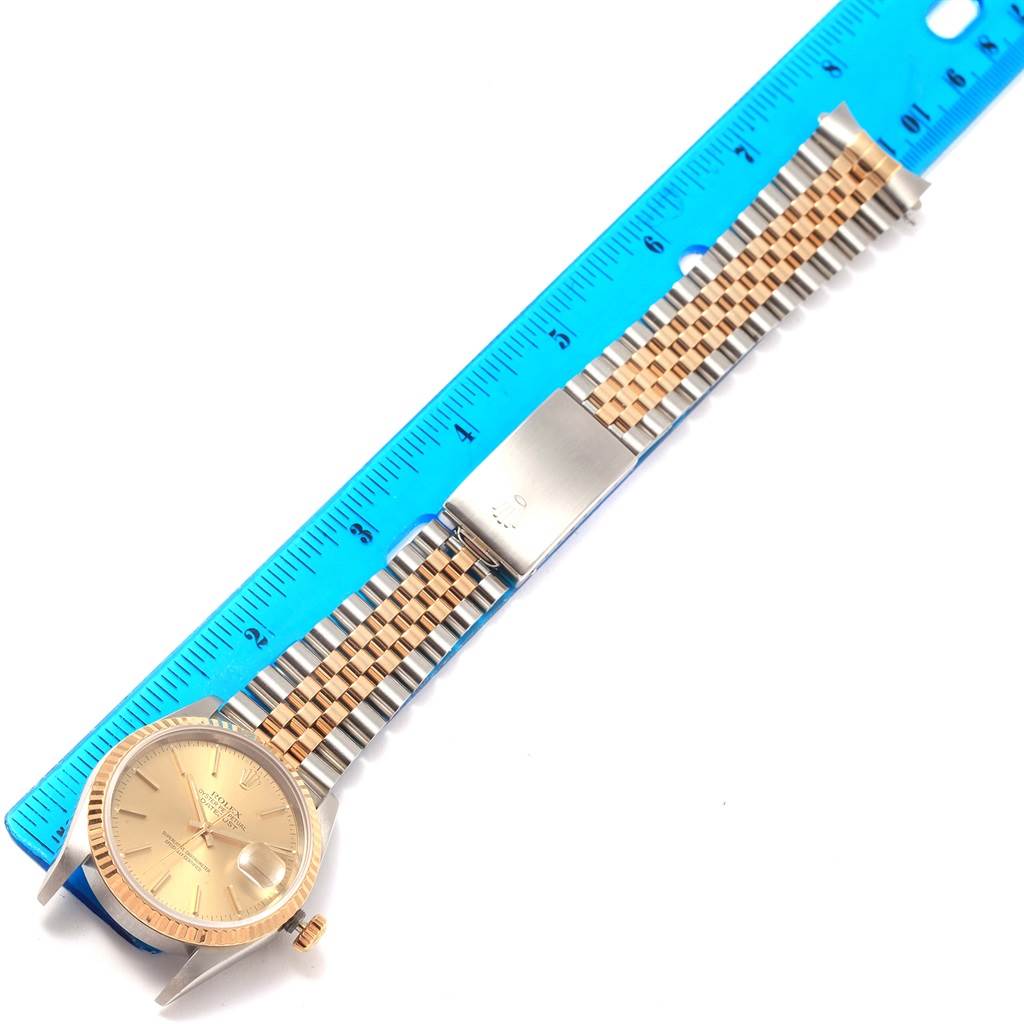 The image shows a Rolex Datejust 16233 Steel and Gold (two tone) Champagne Dial 16233 Steel and Gold (two tone) Champagne Dial watch with a jubilee bracelet, positioned next to a ruler for measurement.