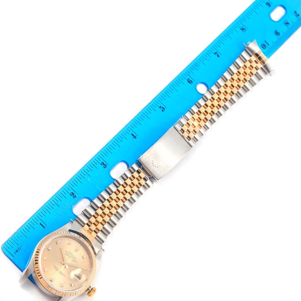 The image shows a top view of a Rolex Datejust 16233 Steel and Gold (two tone) Champagne Dial 16233 Steel and Gold (two tone) Champagne Dial watch with its bracelet measured against a blue ruler.