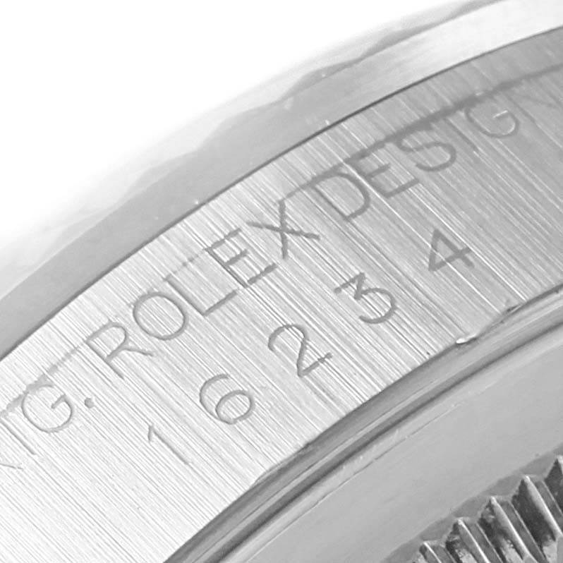 This close-up image shows part of the case with engraved text on the inner bezel of a Rolex Datejust 16234 Men's Stainless Steel Black Dial 16234 Men's Stainless Steel Black Dial watch.