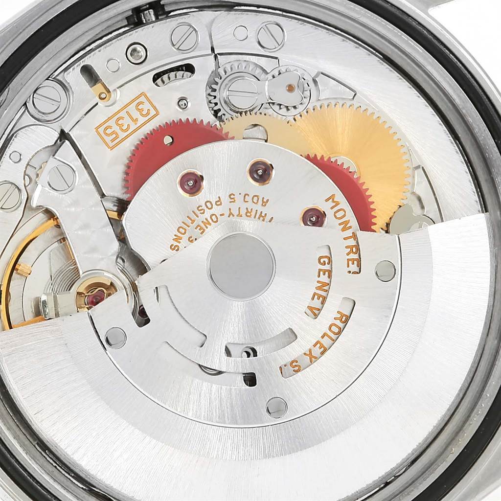 The image shows a close-up view of the movement mechanism inside a Rolex Datejust 16220 Men's Stainless Steel Silver Dial 16220 Men's Stainless Steel Silver Dial watch, highlighting gears and inscriptions.