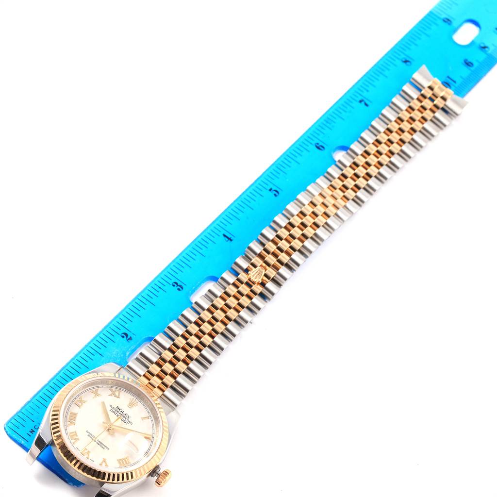 The image shows a Rolex Datejust 116233 Stainless Steel Beige Dial 116233 Stainless Steel Beige Dial watch laid flat next to a blue ruler, displaying its bracelet and face from a top-down angle.