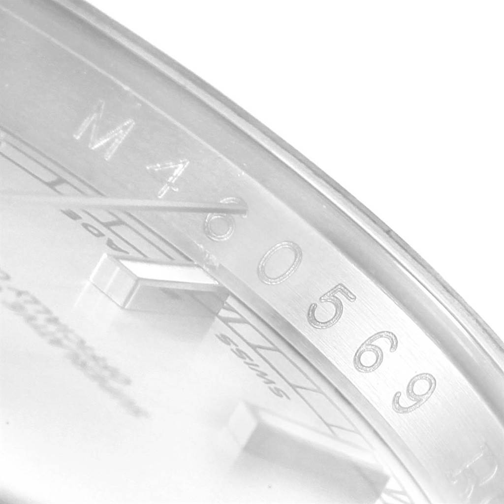 This close-up image of the Rolex Datejust 116200 Men's Stainless Steel Silver Dial 116200 Men's Stainless Steel Silver Dial watch focuses on the rehaut with engraved serial number and part of the dial.