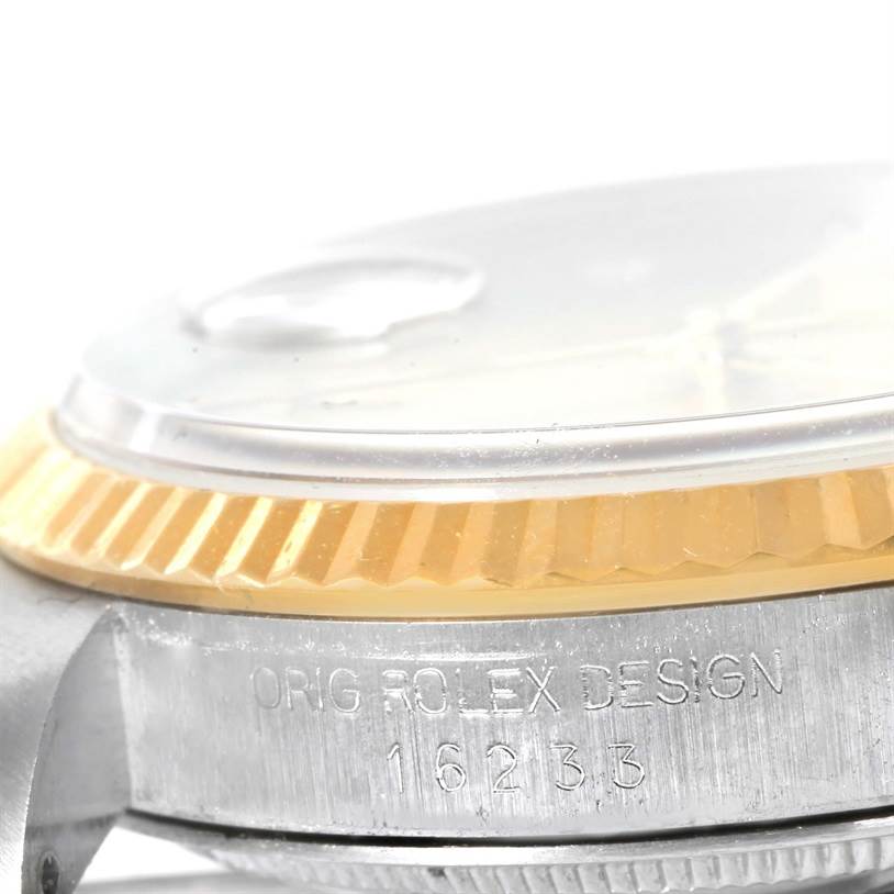 This image shows a close-up side view of the bezel, crystal, and part of the casing of a Rolex Datejust 16233 Men's Steel and Gold (two tone) Champagne Dial 16233 Men's Steel and Gold (two tone) Champagne Dial watch with model number engraved.