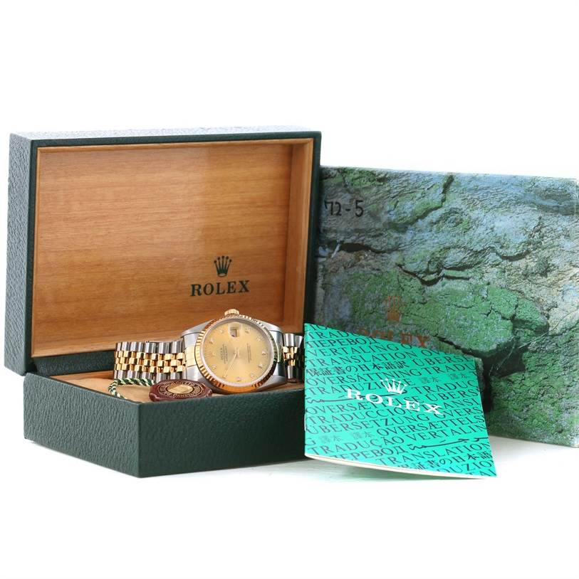 The Rolex Datejust 16233 Men's Steel and Gold (two tone) Champagne Dial 16233 Men's Steel and Gold (two tone) Champagne Dial watch is shown at an angle inside its open box, with accompanying booklet and tags visible.