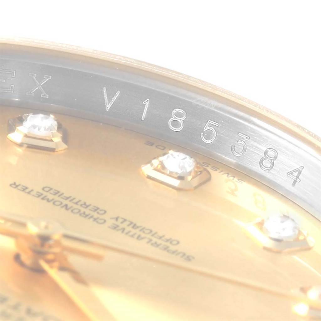 The image shows a close-up of the serial number engraving and part of the dial of a Rolex Datejust 116203 Stainless Steel Champagne Dial 116203 Stainless Steel Champagne Dial watch.